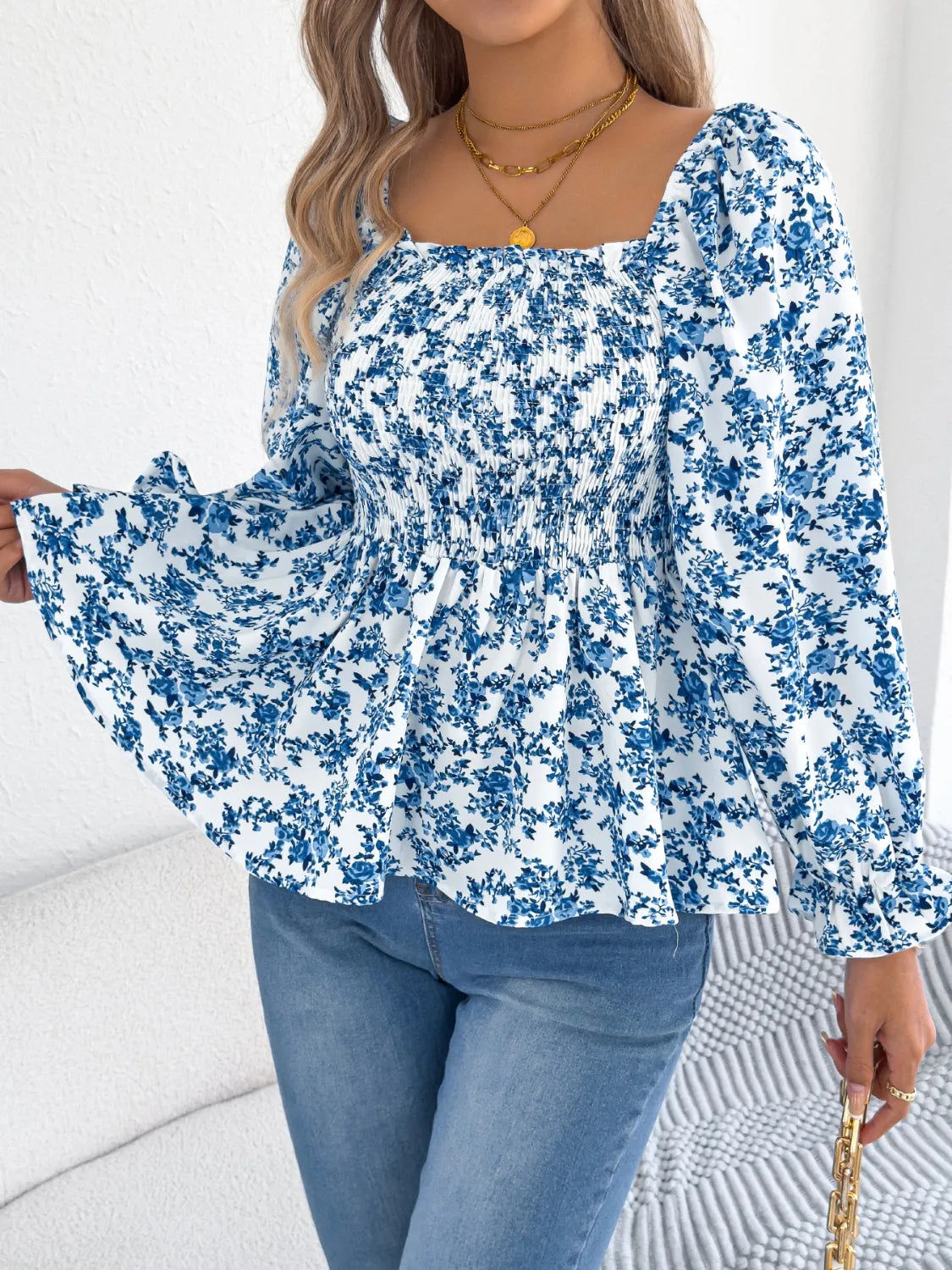 Women's floral blouse with a square neckline and flounce sleeves, featuring a light, airy fabric and a delicate floral pattern.