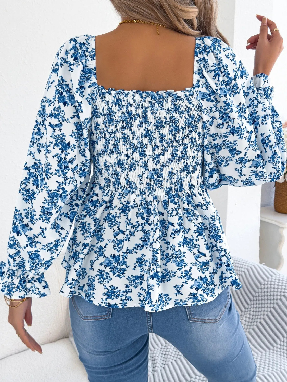 Women's floral blouse with a square neckline and flounce sleeves, featuring a light, airy fabric and a delicate floral pattern.